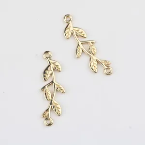 Detail view of gold alloy twig double-loop connector charm for DIY jewelry making.