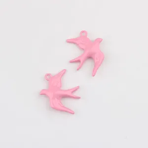 Close-up detailopname van roze emaille zwaluw metaallegering hanger voor DIY sieraden maken.