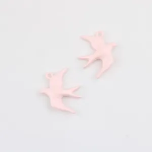 Close-up roze legering zwaluw hanger, gladde gelakte details, ideaal voor DIY sieraden.