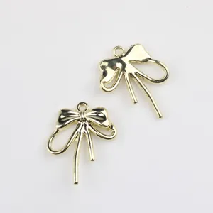 Detail shot of golden alloy bow charms, perfect jewelry accessories for DIY crafting.