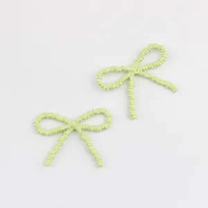 Nahaufnahme von hellgrünen lackierten Legierungs-Schleifen-Anhängern, ideal für DIY-Schmuck.