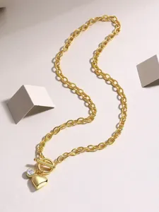 Goldfarbene Kette mit T-Verschluss, funkelndem Steinhänger und elegantem Herz-Anhänger Detail.