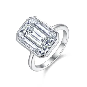 Emerald cut moissanite ring detail, sleek bezel set silver band for modern elegance design.