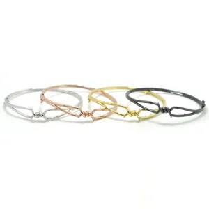 Detailansicht minimalistischer Stacheldraht verdrehter Metallarmbänder in vier Farben.