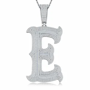 Gros plan détaillé du pendentif lettre E gothique glacé en argent S925 avec des pierres scintillantes.