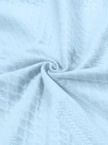 Vue macro détaillée du sweat-shirt en tricot bleu clair montrant la texture jacquard