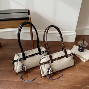 Vue détaillée de sacs à épaule en toile vintage avec lanières en cuir et charmant pendentif.