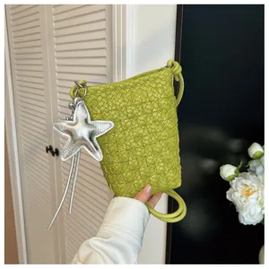 Detailansicht der grünen geflochtenen Handytasche mit stylischem silbernen Sternanhänger.