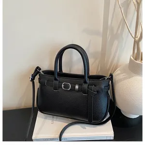 Zwarte gestructureerde lederen handtas detail, stijlvol handvat en crossbody riem ontwerp.