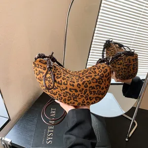 Vue détaillée du sac croissant imprimé léopard, montrant la lanière nouée et la texture douce.