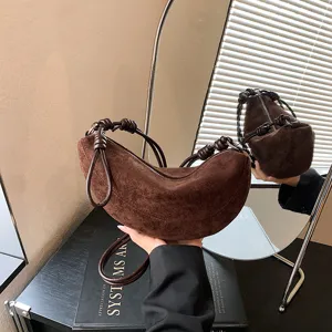 Vue de detail du sac a main croissant en daim marron avec poignee nouee et fermeture eclair.