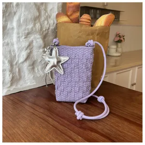 Nahaufnahme der violetten geflochtenen Handytasche mit einem schicken silbernen Sternanhänger.