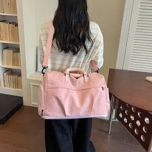 Large capacity pink travel duffel bag with star moon pattern and shoulder strap detail.