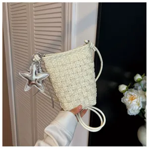 Detailansicht der weißen geflochtenen Handytasche mit silbernem Sternanhänger.