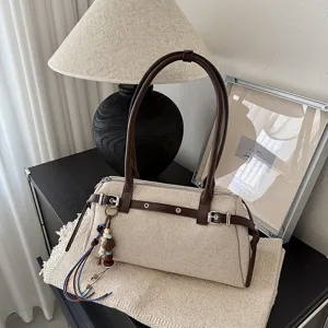 Sac à épaule rétro en toile avec bordure en cuir marron, boucle élégante et breloque perlée chic.
