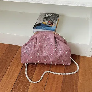 Detail view of the elegant pink metallic pearl evening clutch bag with pearl strap.