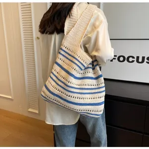 Detail view of a beige and blue striped crochet tote bag, casual hollow knit shoulder bag.