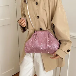 Pink pearl clutch bag detail view, shiny shell design with elegant pearl chain strap.