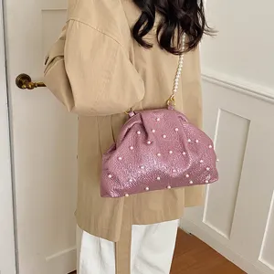 Detailed shot of the pink pearl embellished shell shoulder bag, showcasing stylish texture.