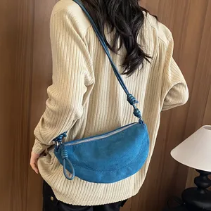 Sac à épaule bleu style croissant vintage, design tendance avec bandoulière nouée pour femme.