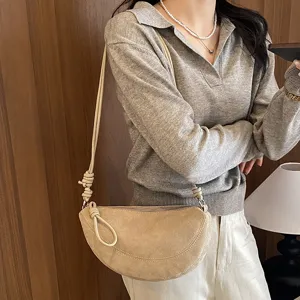 Vue détaillée du sac porté épaule croissant femme, texture suédine douce, sac tendance beige.