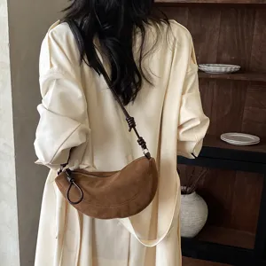 Sac porté épaule croissant en daim marron, sac bandoulière chic avec lanière à nœuds.
