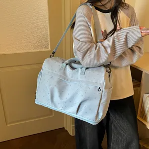 Detailed view of the stylish light blue travel duffel bag with star and moon print, spacious.