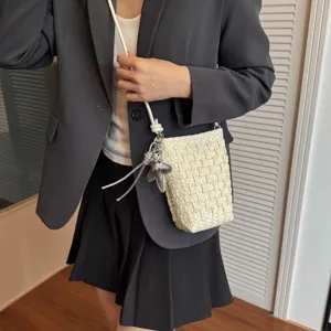 Detailaufnahme der gewebten Mini-Handytasche mit silbernem Seestern-Anhänger, schick.