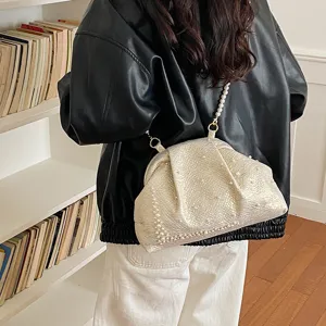 Crossbody pearl shell bag detail showing ruched leather and elegant evening clutch design.