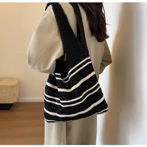 Detailed view of a stylish black and white striped crochet shoulder tote bag for women.