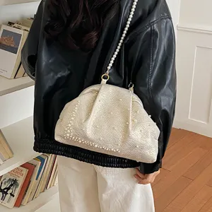 Detail view of a vintage style pearl beaded shell shoulder bag showcasing intricate texture.
