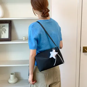 Borsa a tracolla minimalista nera da donna con ciondolo a stella per uso quotidiano.