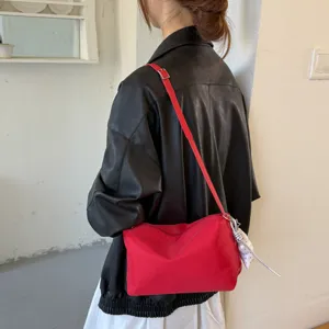 Vista dettagliata di una borsa a spalla minimalista rossa, leggera e chic per ogni giorno.