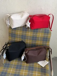 Borsa a tracolla casual minimalista da donna, leggera borsa a cuscino in nylon con grazioso ciondolo.