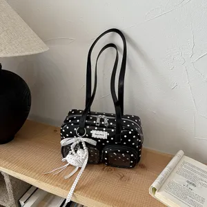 Sac à bandoulière noir et blanc à pois avec double sangle et poches avant transparentes.