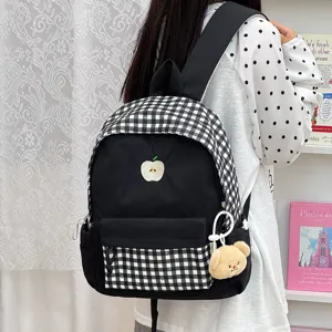 Détail en gros plan d'un joli sac à dos à carreaux noir et blanc avec broderie de pomme.