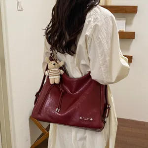 Wine red PU leather shoulder bag, large capacity versatile commuting backpack for women.