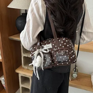 Brown polka dot shoulder bag with clear front pockets and cute ribbon pendant detail.