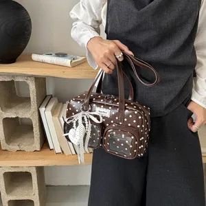 Stylish brown polka dot underarm bag with clear front pocket, perfect for daily commute.