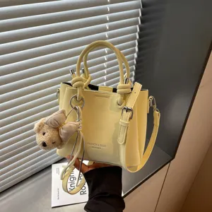 Bolso tipo cubo de cuero amarillo estilo coreano con colgante de osito y bolso de mano.