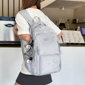 Vista dettagliata dello zaino grigio chiaro con stampa di stelle e tasche multiple pratiche.