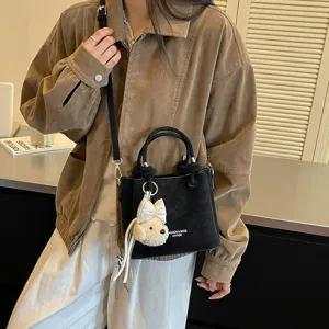 Bolso cubo cruzado negro de estilo coreano con un lindo colgante de oso muy elegante.