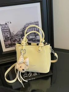 Bolso tipo cubo de piel sintética en color amarillo con tierno colgante de oso, elegante bolso.