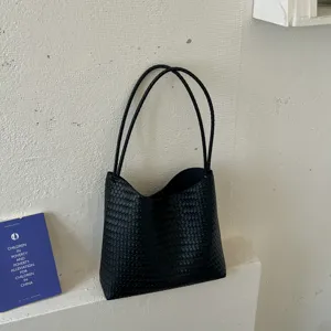 Close-up detail shot of the black woven leather shoulder tote bag, stylish and practical.