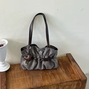 Borsa a tracolla grigia effetto camoscio con manici marroni e ciondolo a cuore per ogni giorno.
