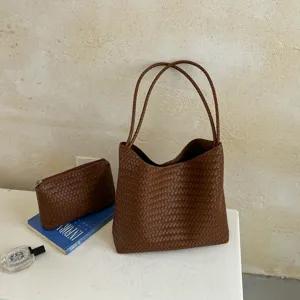 Detailed view of brown woven leather tote bag, luxury style shoulder bag with small pouch.