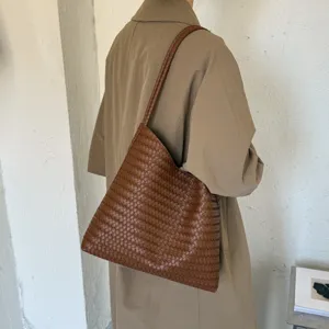 Detailed view of the brown woven leather shoulder bag featuring intricate texture and craftsmanship.