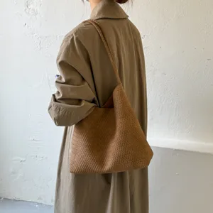 Detailed view of the brown woven leather shoulder bag, showcasing premium texture and large capacity.