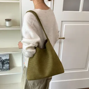 Detailed shot of olive green woven leather shoulder tote bag, elegant minimalist daily style.
