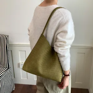 Detailed view of the woven shoulder tote bag in green, showcasing premium texture and capacity.